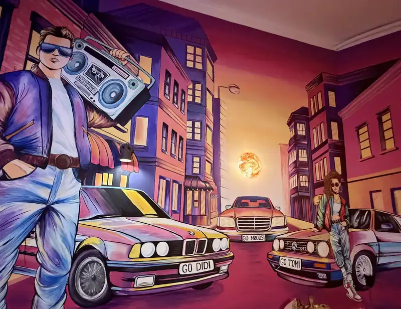 Mural z bohaterem z lat 90., magnetofonem i samochodem